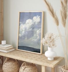 a shelf with baskets and vases on top of it next to a framed painting