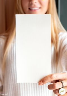 a woman holding up a white piece of paper