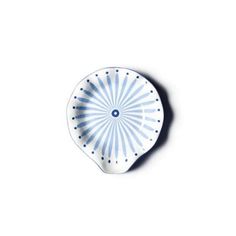 a blue and white plate with a circular design on it's side, against a white background