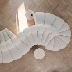 an overhead view of a living room with wood flooring and white furniture on top of it