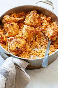 a pan filled with chicken and rice on top of a table