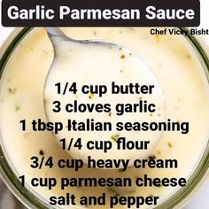 the ingredients for garlic parmesan sauce in a glass jar with a spoon inside