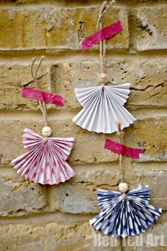 three paper fans hanging on a brick wall