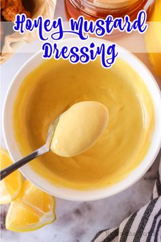 honey mustard dressing in a white bowl with a spoon and lemons on the side