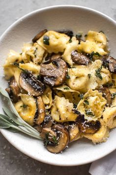 a white bowl filled with pasta and mushrooms