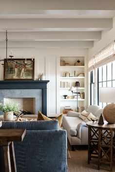 a living room filled with furniture and a fire place under a painting on the wall