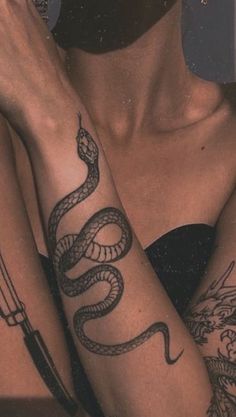 two women with tattoos on their arms and one has a snake tattooed on her arm