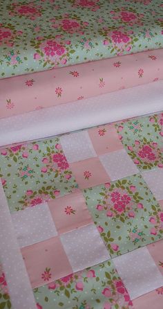 a pink and green quilt with flowers on it