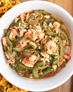 a white bowl filled with green beans and shrimp