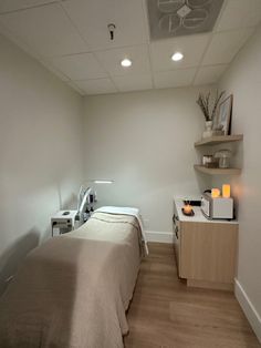 a room with a bed and some shelves on the wall next to it that is empty