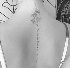 the back of a woman's neck with flowers on it