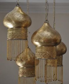 three gold colored chandeliers hanging from the ceiling