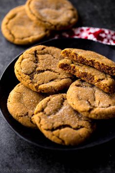 some cookies are on a black plate and one is cut in half