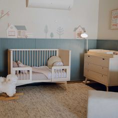 a baby's room with a crib, rocking horse and dresser in it