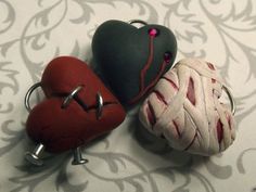 three heart shaped objects are sitting on a tablecloth with a silver hook in the middle