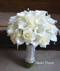 a bridal bouquet with white roses and pearls