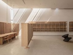 an empty room with several wooden shelves and chairs on the floor in front of them