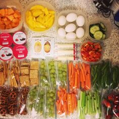 many different types of food are laid out on the counter top, including carrots, celery, cucumbers and other vegetables