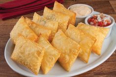 some food is sitting on a white plate with sauces and condiments around it