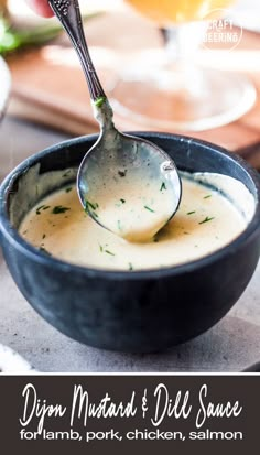 a close up of a bowl of dip with a spoon in it and the words dipm mustard dill sauce