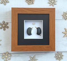 two penguins in a shadow box surrounded by snowflakes