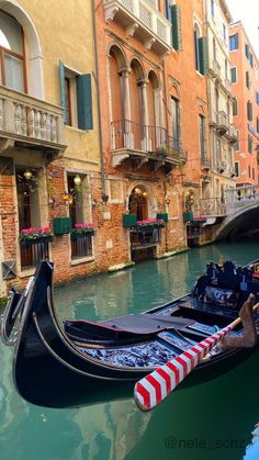 a gondola is parked on the side of a canal