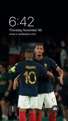 two soccer players are hugging each other in front of an iphone screen with the date on it