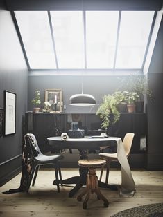 a table with two chairs and a laptop on it in a room that has skylights