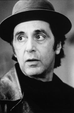 a man wearing a hat and looking at the camera with an intense look on his face