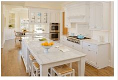 a large kitchen with white cabinets and an island