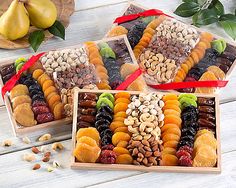 four wooden boxes filled with assorted fruit and nuts