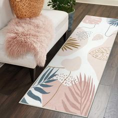 a living room area with a rug, chair and potted plant