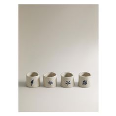 four white cups sitting next to each other on a table