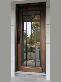 a wooden door with glass on the side of it and an iron gate in front