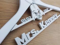 two star wars themed wooden name tags on top of a wood table with white scissors