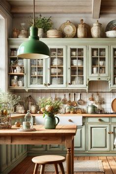 a kitchen filled with lots of green cupboards and wooden flooring next to a counter top