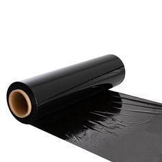 a roll of black plastic film sitting on top of a white surface