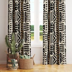 the curtains are decorated with black and white geometric designs, along with a cactus in a basket