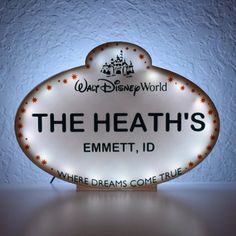 the sign is lit up in front of a white wall with writing on it that says, the heath's emmet, i d where dreams come true