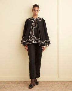 This cape is inspired by an Edwardian gown. We have reproduced the decorative embellishments in couching embroidery, a style in which a cord is laid in patterns on the fabric and secured with perpendicular stitches.  Four front buttons 100% merino wool Made in India Dry clean only View all outerwear Vanessa is 5'9" and Luxury Traditional Cape Outerwear, Luxury Embroidered Sets With Cape Sleeves, Embroidered Fitted Sets With Cape Sleeves, Luxury Traditional Cape-style Outerwear, Designer Embroidered Cape Sets, Cape Shirt, Couching Embroidery, Baptism Gown, New York Mens