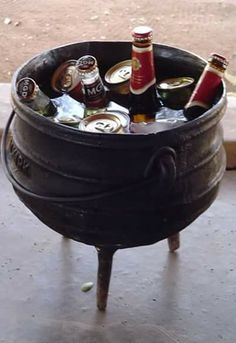 a metal bucket filled with beer bottles on top of a wooden table