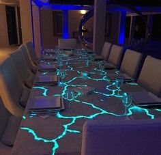 a long table is lit up with glowing blue lights and the words custom dinner table on it