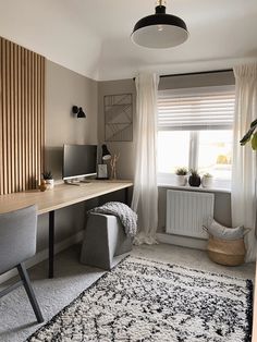 a room with a desk, chair and rug in it