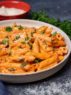 pink sauce pasta in a white bowl with parsley on top and text overlay that reads, pink sauce pasta