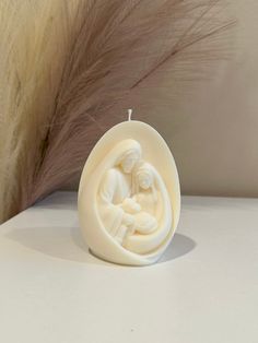 a candle that has been carved to look like an egg with a baby in it