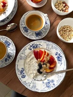 a table topped with bowls and plates filled with food next to cups full of liquid