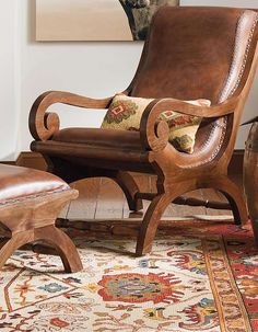 a chair and ottoman in a living room with rugs on the floor next to it