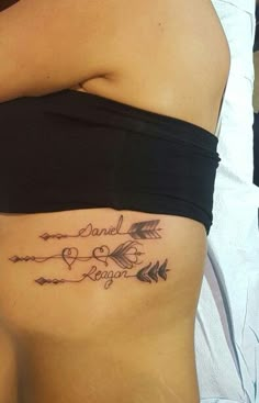 a woman's stomach with an arrow tattoo on it