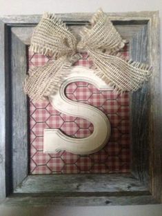 the letter s is made out of wood and burlock with a bow on it