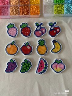 beaded fruit and vegetables are displayed in front of some plastic trays filled with beads